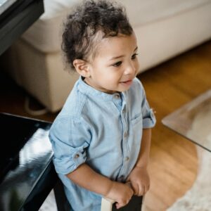 Charming toddler holding a frame standing in a stylish, inviting living room